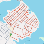 A map showing a route through a neighborhood labeled Riviera Beach. Red arrows mark the pathway, starting at a green marker and ending at a red marker. Street names like Riverview, Bayside, and Harbor are visible. Water bodies surround the area.